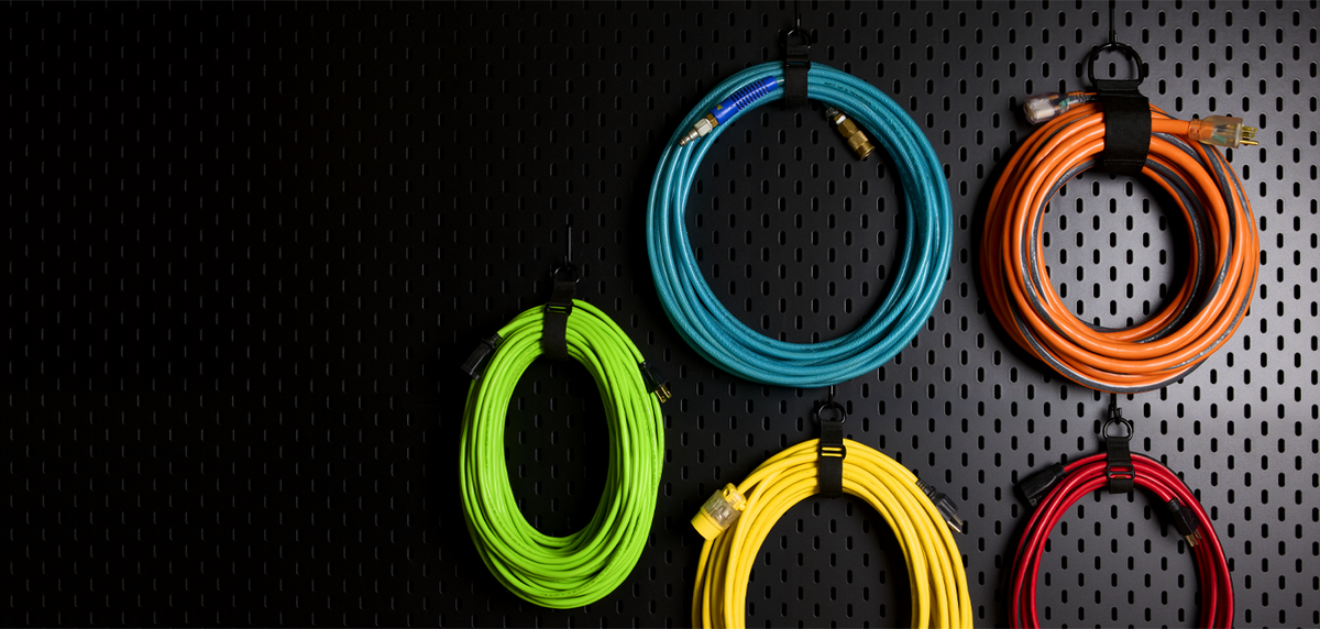 Coloured cables hung on a black pegboard with Totem straps